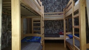 A bunk bed room with a patterned wallpaper, wooden bunk beds, and a red object on the floor. - Yourhostel Pechersk (Kyiv)