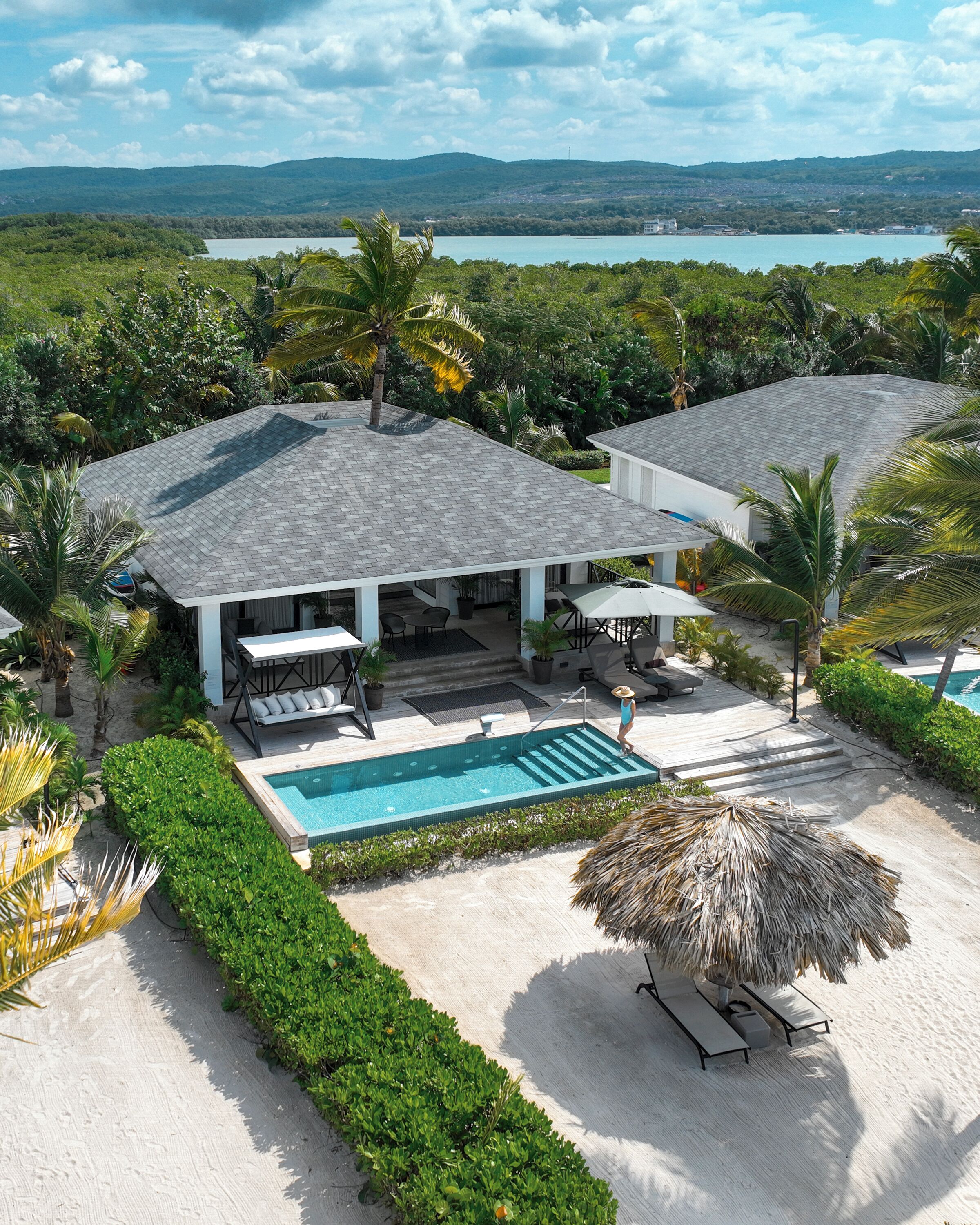 A resort with a pool, outdoor seating, and a view of the water.
