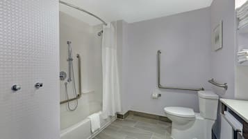A bathroom with a shower, toilet, and grab bars.