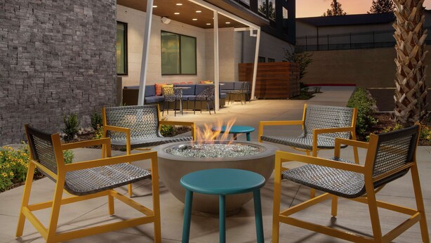 An outdoor seating area with a fire pit, chairs, and tables. - Tru by Hilton San Antonio Lackland Sea World (San Antonio)