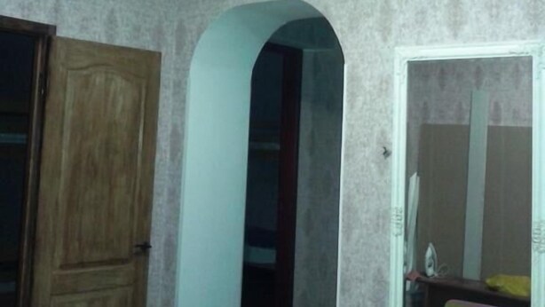 A room with a wooden door, an arched doorway, and a mirror on the wall. - Yourhostel La Femme (Kyiv)