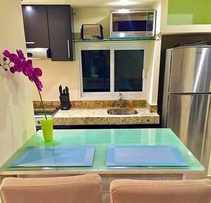 A compact kitchen with a microwave, sink, and refrigerator. - Chic Beach Studio Romantic Zone Pool Ocean View (Amapas)