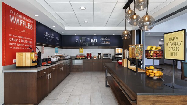 A modern kitchen with a waffle station, a coffee machine, and a fruit bowl. - Hampton Inn & Suites D'Iberville Biloxi (D'Iberville)