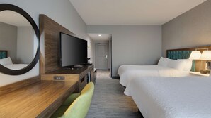 A hotel room with a bed, a desk with a TV, a chair, and a mirror. - Hampton Inn & Suites D'Iberville Biloxi (D'Iberville)