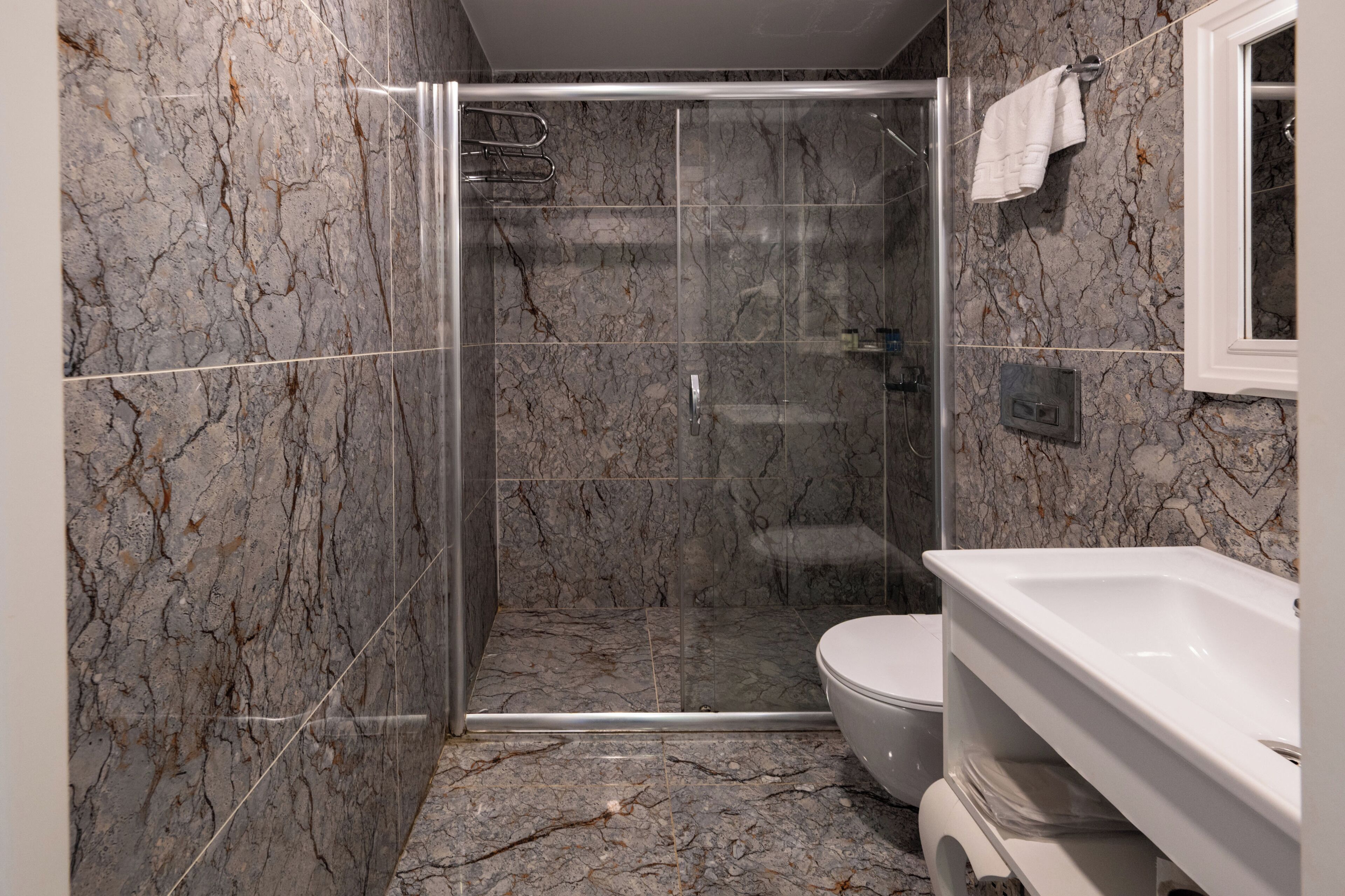 A bathroom with a shower, toilet, and sink.