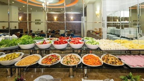 A buffet with various dishes, including salads, vegetables, and meats, in a modern restaurant setting. - Kunlun Kensington Hotel (Istanbul)