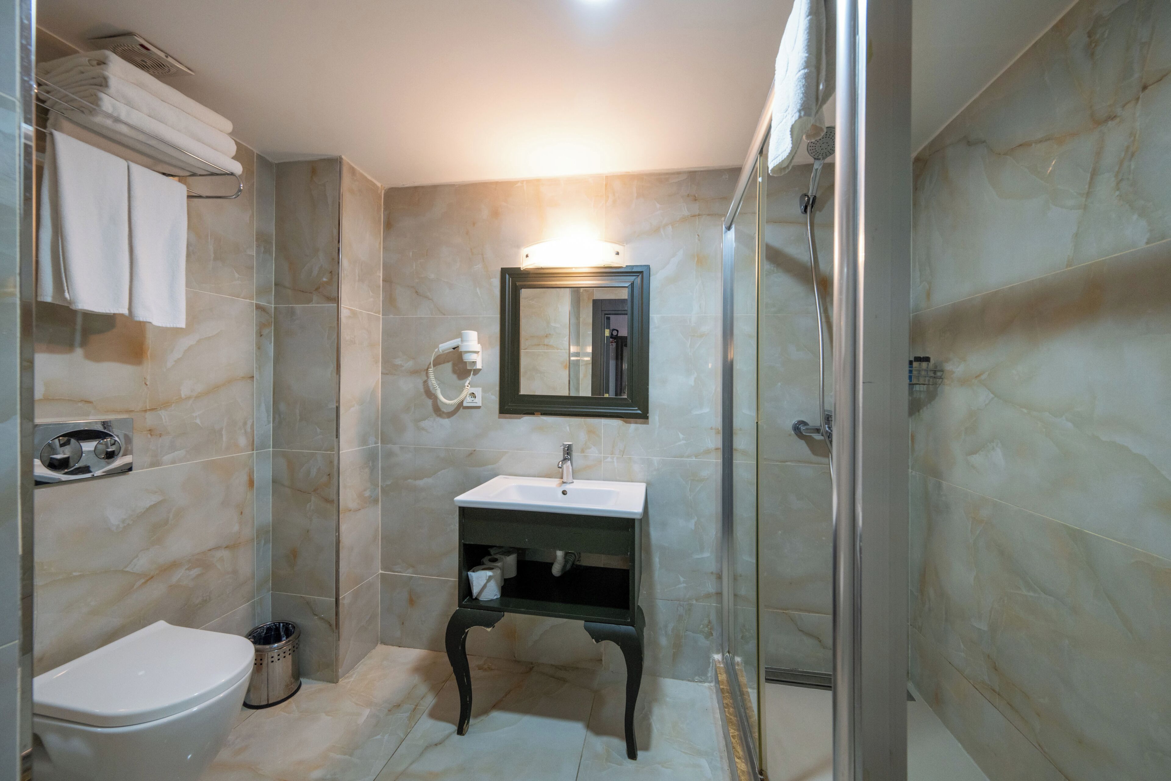 Un baño con inodoro, lavabo y ducha.