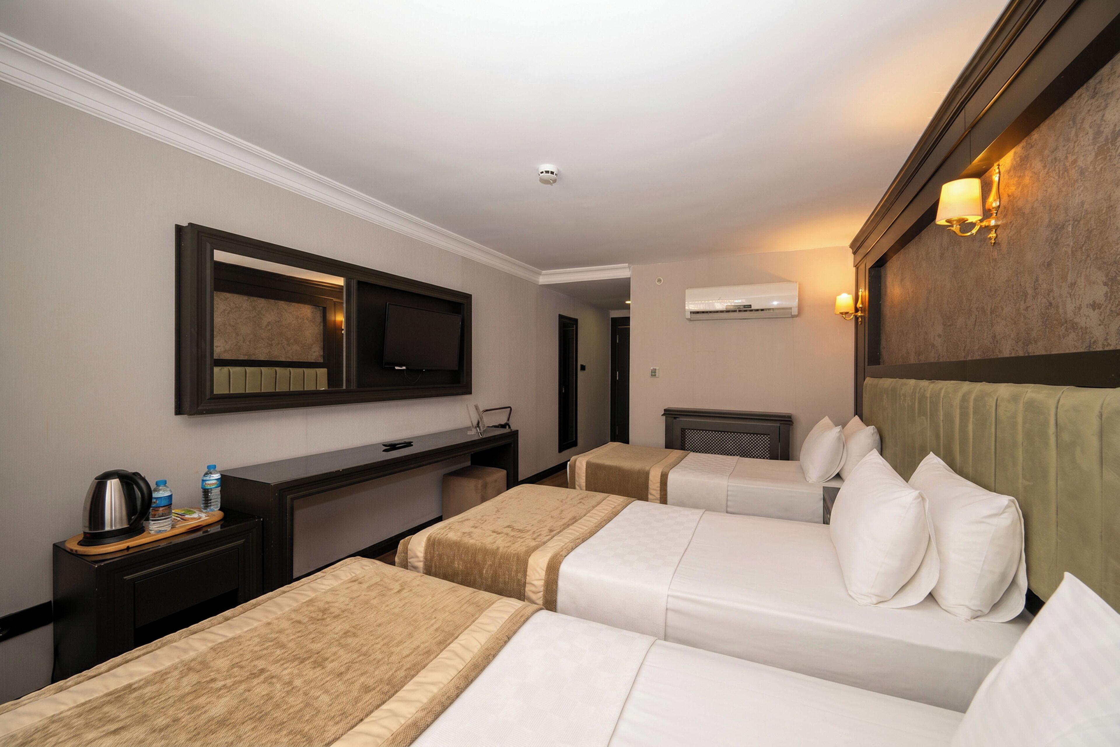 Una habitación de hotel con dos camas, un escritorio, televisor y minibar.