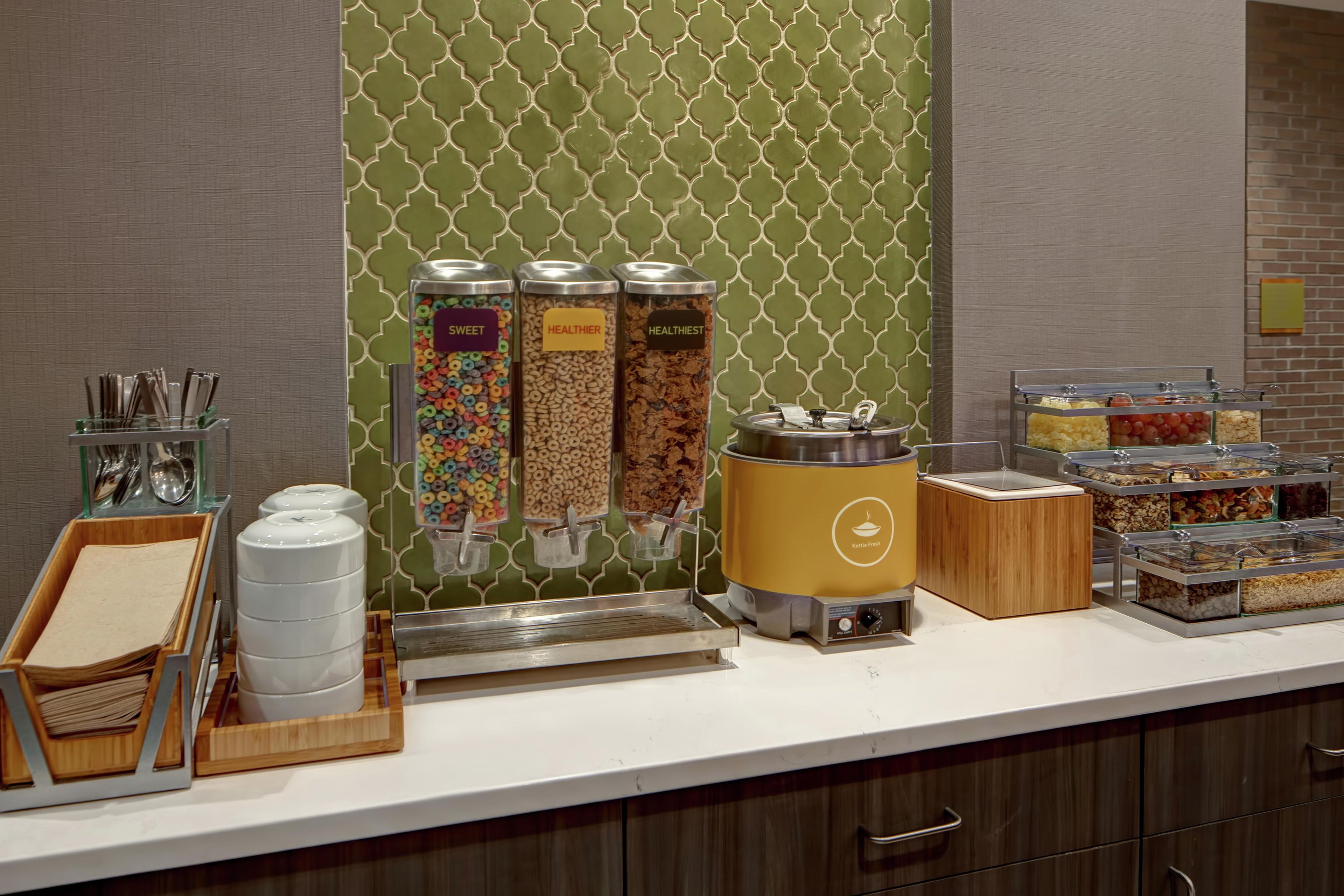 A buffet setup with various food containers and utensils.