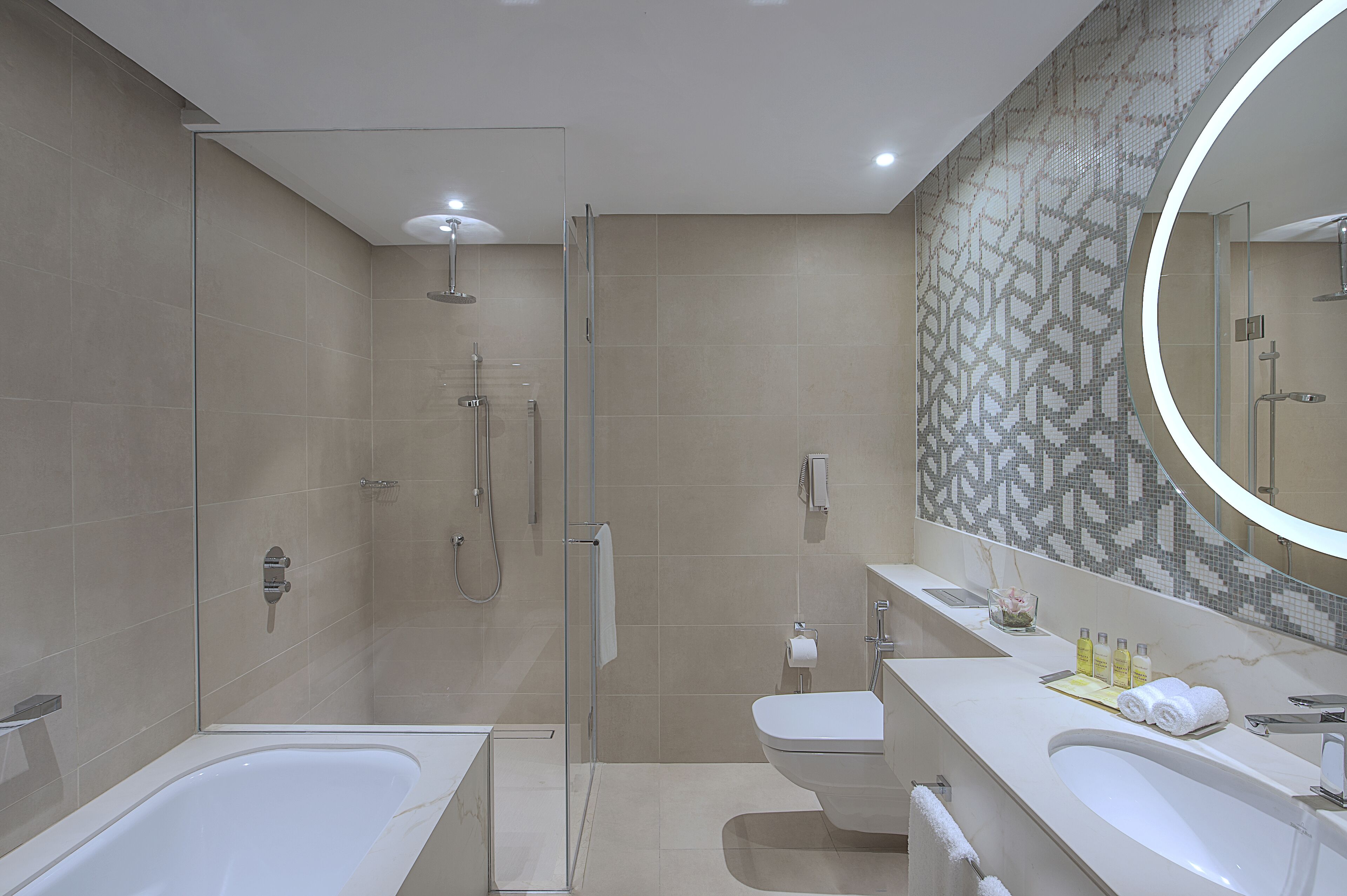 A modern bathroom with a glass-enclosed shower, a freestanding bathtub, and a vanity with a mirror.