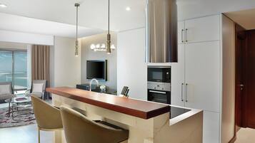 A modern kitchen with a central island, stainless steel appliances, and a dining area with a view.