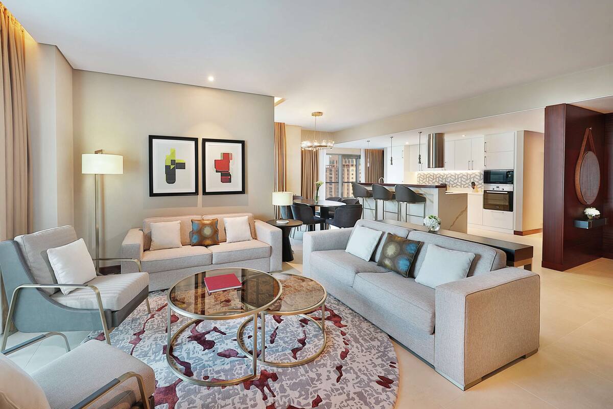 Une chambre d’hôtel moderne dotée d’un espace de vie, d’un coin repas et d’une kitchenette.