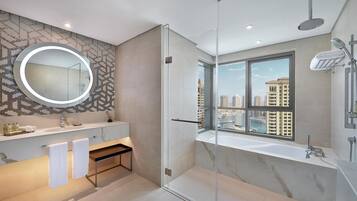A modern bathroom with a glass-enclosed shower, a large mirror, and a view of a marina through a large window.