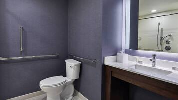 Ein modernes Badezimmer mit Toilette, Waschbecken und Spiegel.