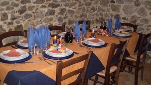 A dining table set with plates, cutlery, and napkins, surrounded by chairs. - Agriturismo Cavallin del Bufalo (Manciano)