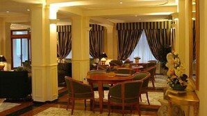 Un coin repas avec une table ronde, des chaises et des rideaux.