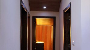 A hallway with wooden flooring and a ceiling light.