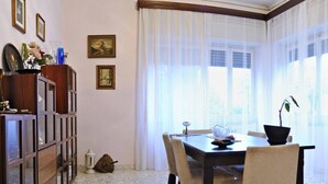 Comedor con una mesa, sillas, una lámpara y un cuadro sobre caballete.