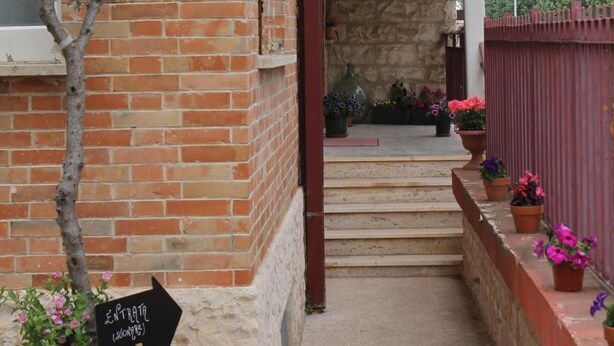 Fachada de un edificio con un letrero que dice "ONONNE" y una señalización que indica "ENTRADA (SALÓN)".