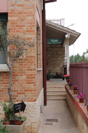 Fachada de un edificio con un letrero que dice "ONONNE" y una señalización que indica "ENTRADA (SALÓN)".