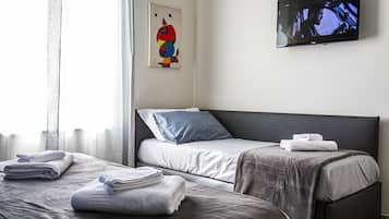 Habitación triple Deluxe | Edredón, camas con efecto memoria y caja de seguridad en la habitación