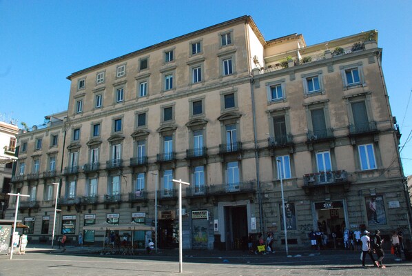 A multi-story building with a classic architectural style, featuring a central entrance with a sign, multiple windows, and balconies. - Garibaldi 136 (Naples)