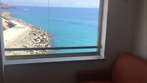 A room with a large window overlooking a rocky coastline and the sea. - CasaMIA a Marina di Camerota (Camerota)