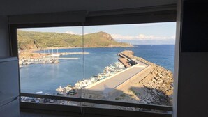 A view from a window overlooking a marina with boats, a breakwater, and a hilly landscape. - CasaMIA a Marina di Camerota (Camerota)