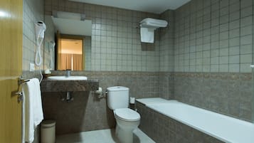 A bathroom with a toilet, sink, and bathtub.