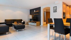 Een moderne woonkamer met een bank, salontafel en tv-meubel.