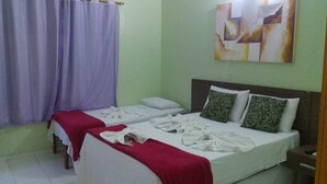 A room with two beds, a painting on the wall, and a curtain. - Pousada Caminho de Pedras (Cairu)