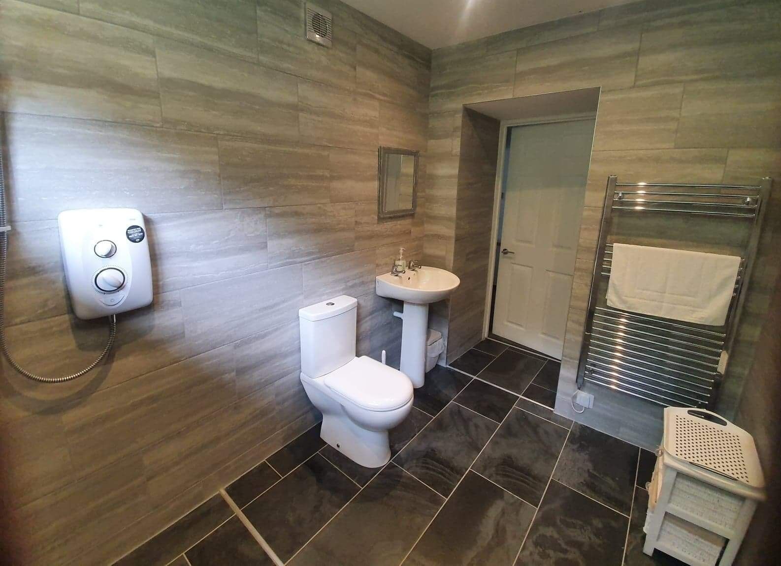 A bathroom with a toilet, sink, and shower area.