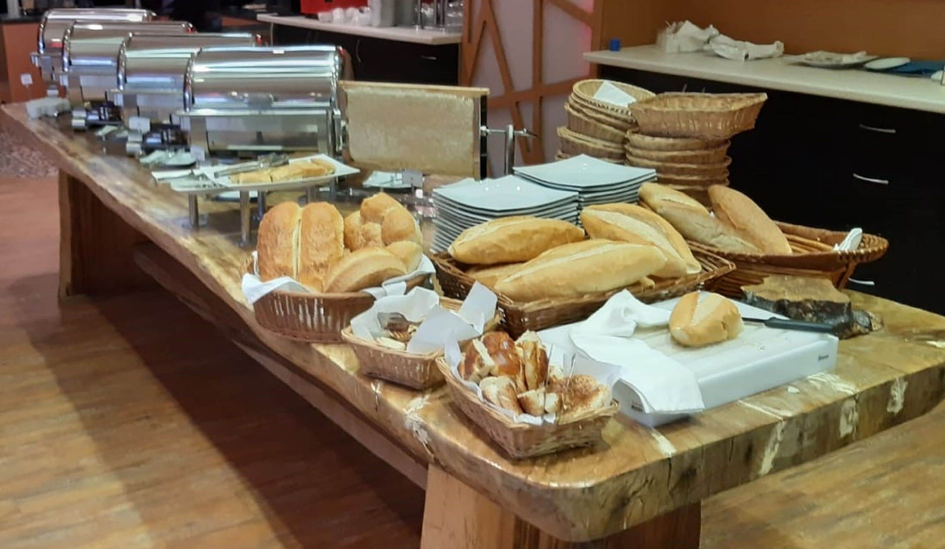 A buffet table with various breads and pastries.