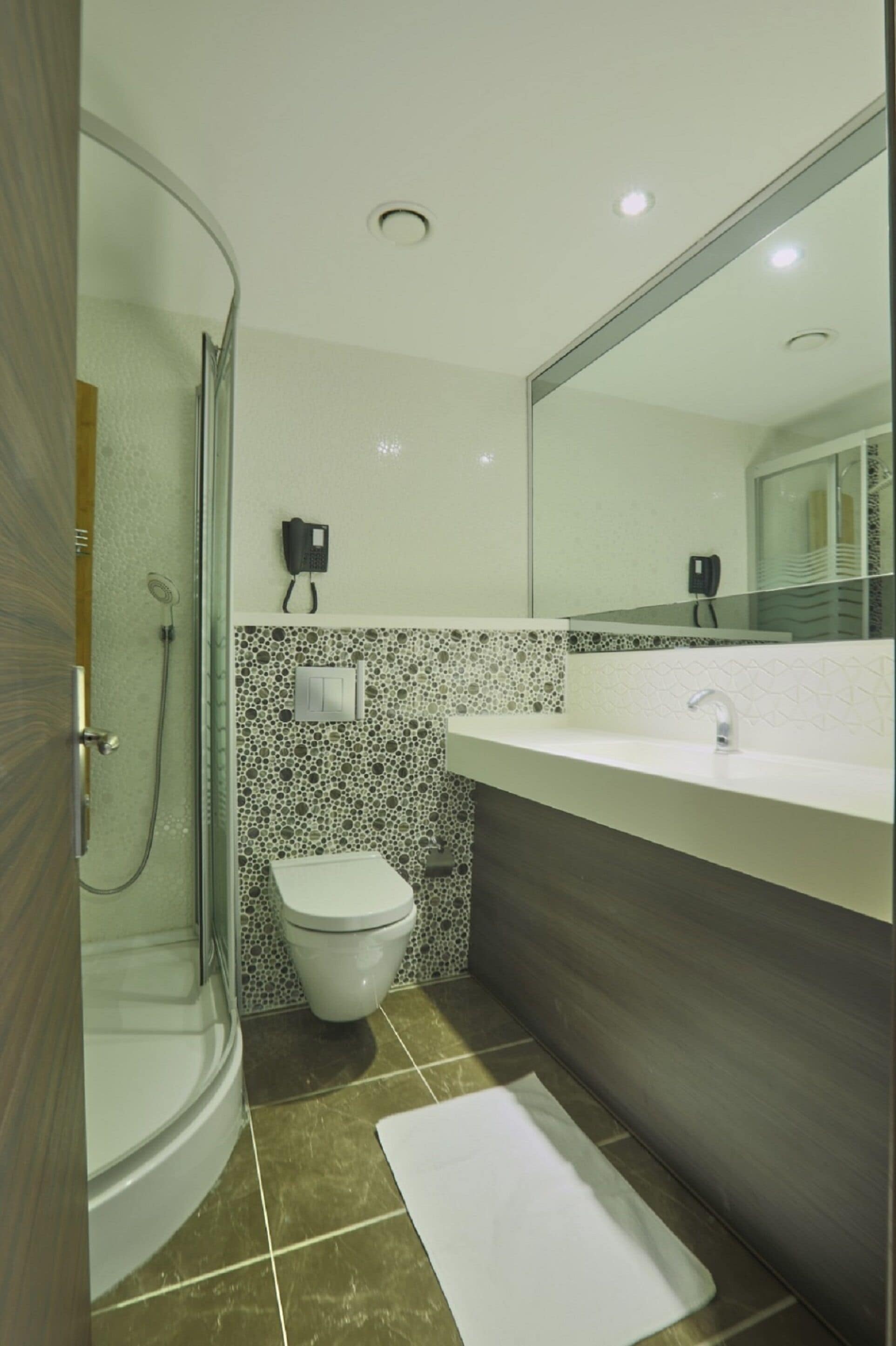 Ein Badezimmer mit Dusche, Toilette und Waschbecken.