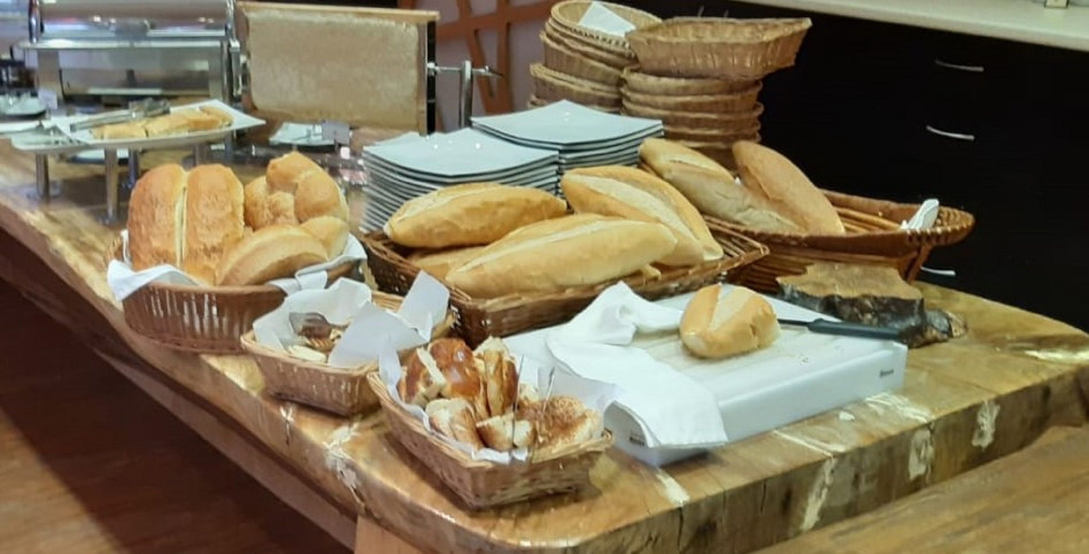 A buffet with various breads and pastries.