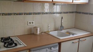 A compact kitchen with a stove, oven, dishwasher, and sink. - Housing near downtown (Montpellier)