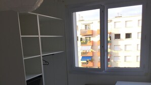 A room with a white desk, a chair, and a window with a view of buildings. - Housing near downtown (Montpellier)
