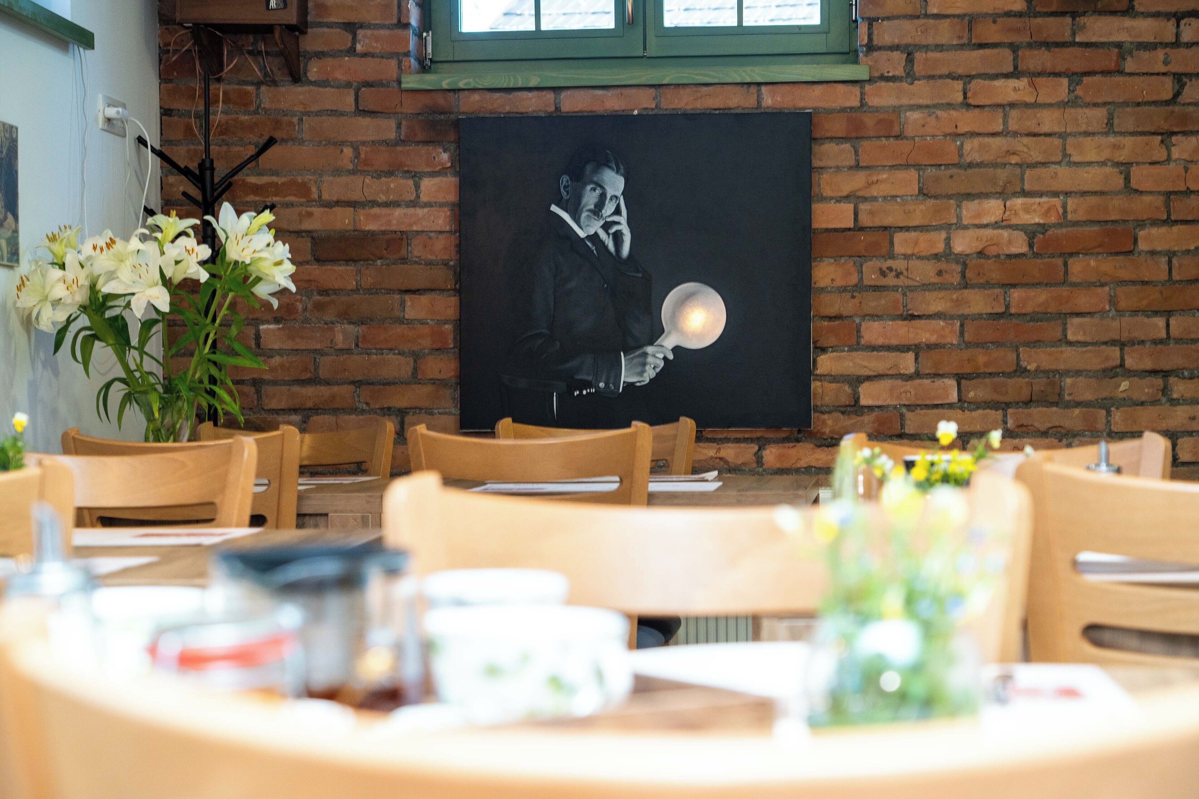 Un restaurante con paredes de ladrillo, sillas de madera y una mesa dispuesta para comer.