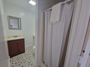 A bathroom with a white sink, mirror, and tiled floor.