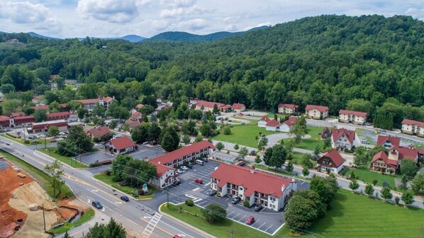 A residential area with houses, a parking lot, and a road. - Alpine Rose - Pet-Friendly, Cozy Cabin w/Hot Tub (Helen)