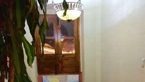Una scala con ringhiere in legno, una porta di legno e un punto luce a parete.
