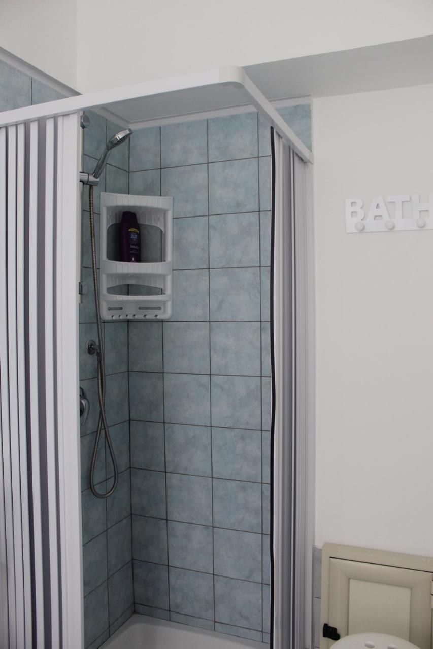 A bathroom with a shower, a toilet, and a sink.
