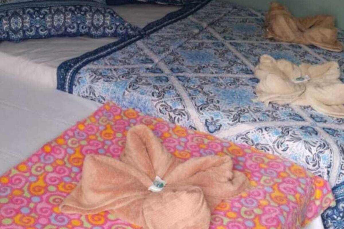 Ein Hotelzimmer mit zwei Betten, jeweils mit gemusterten Bettdecken und Kissen.