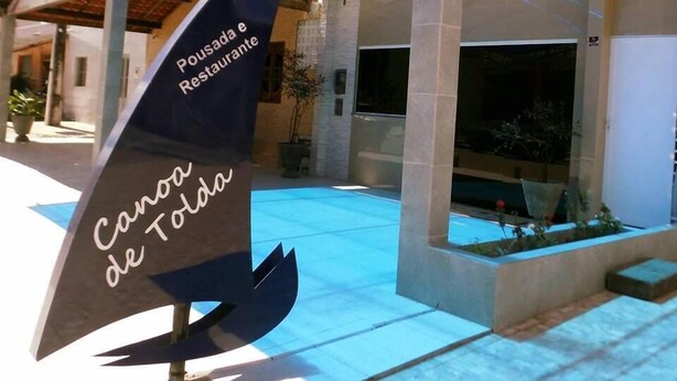 Un edificio con toldo azul y un letrero que dice "Pousada e Restaurante".