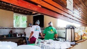 Una zona de cocina con vigas de madera en el techo, una ventana con vegetación en el exterior y un letrero sobre la encimera.