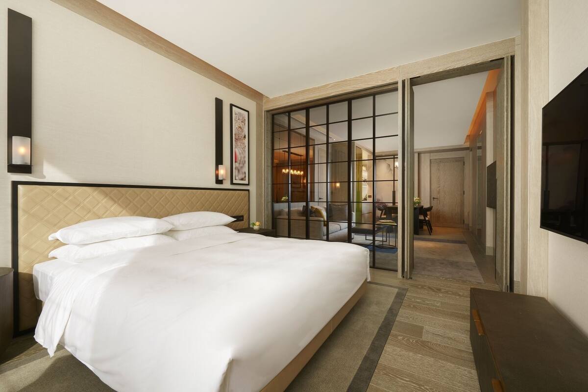Ein Hotelzimmer mit einem großen Bett, einem Schreibtisch und einem Fernseher.