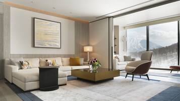 A modern living room with a sofa, armchair, coffee table, and a large window with a mountain view.