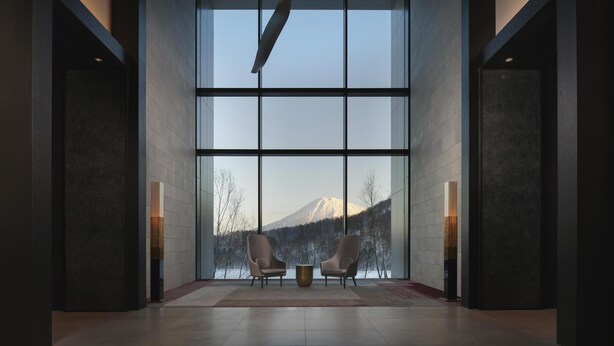 A modern interior with large windows, two armchairs, and a central table. - Park Hyatt Niseko Hanazono (Kutchan)