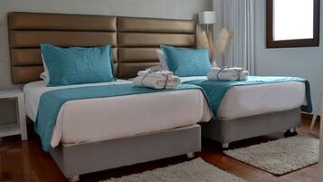 Una cama doble con cabecera, dos almohadas y una toalla doblada.