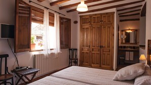 Ein Schlafzimmer mit einem Bett, einem Holzschrank und einem kleinen Tisch mit Stuhl.